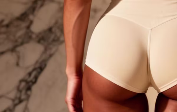 Brazilian Butt of female in cream shorts